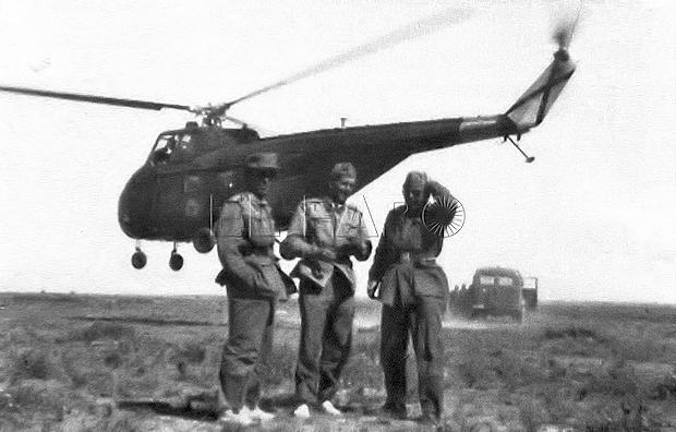 El entonces capitán de Estado Mayor con dos oficiales en una operación, mientras un helicóptero del Ejército del Aire sobrevuela el terreno.