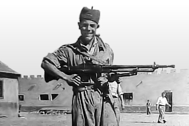 El soldado Nazario Selles Buforn porta el fusil ametrallador del cual él era un experto tirador. 