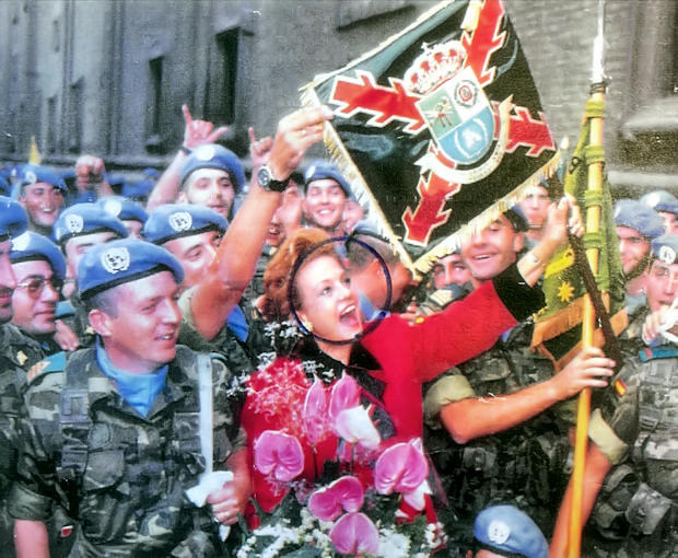 Carmen Sevilla despide a los cascos azules de la Agrupación Aragón con la bandera en mano. (Foto: Época)