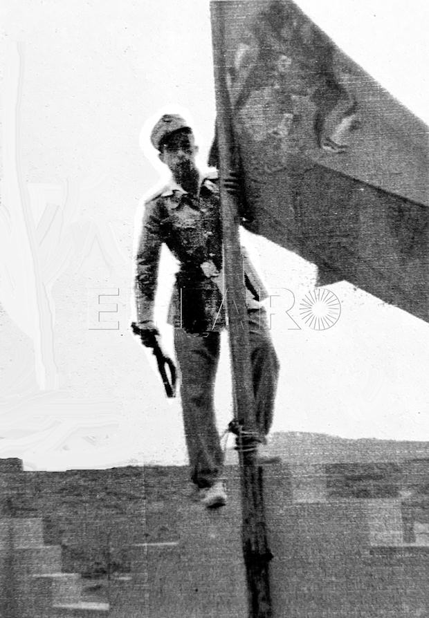 El cabo Manuel Castilla Díaz en lo alto del puesto de Telata agarrado al mástil donde ondea la bandera de España.
