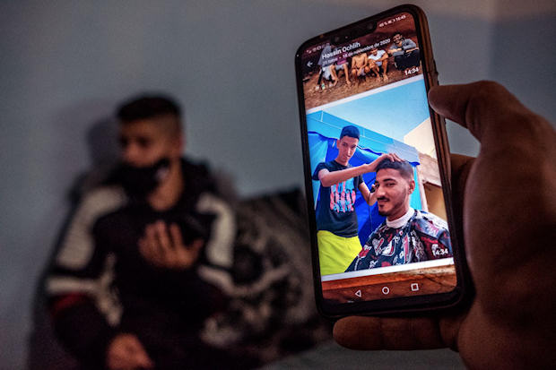 Mohamed Bouhafra muestra una foto en la que su amigo Hossine Ochlih le corta el pelo. (Foto: Javier Bauluz)