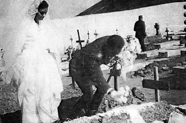 El entonces teniente Emilio Atienza Vega y su esposa Conchita Rodríguez Santafé depositando el ramo de novia en la tumba de un soldado de Tiradores.