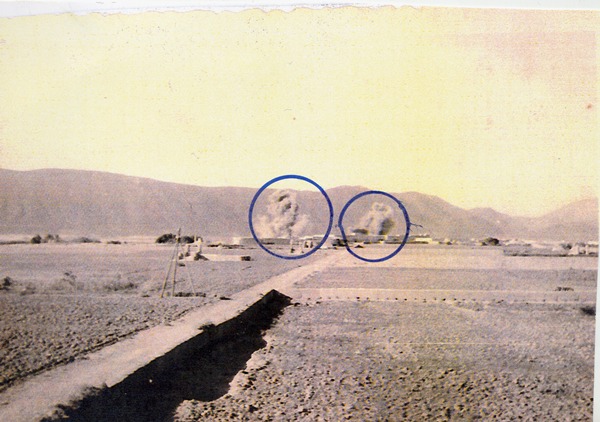 En los dos círculos de la imagen se observan las explosiones del bombardeo de los Heinkel en el momento del salto paracaidista en Tiluin, en una foto tomada por Antonio Pérez Pérez, policía en Ifni. | DA