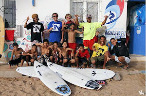 Los miembros de la Escuela de Surf Las Dunas durante su estancia en Sidi Ifni, con Hicham (agachado con camiseta amarilla) y un grupo de niños ifneños.