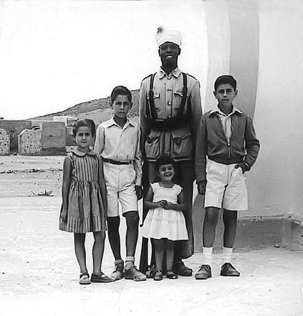 Los hijos del teniente Yanes en la entrada del puesto de Tiugsa-Tagragra, junto a un policía indígena. Verano de 1956.